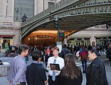 A tour guide leading a lecture outside the terminal