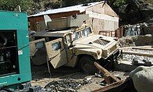 View of a pockmarked armored Humvee at COP Keating, severely damaged during the Battle of Kamdesh.