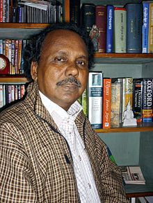 Portrait of a man standing in font of bookshelf