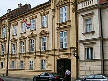 Tan, older two-story building with flag in front