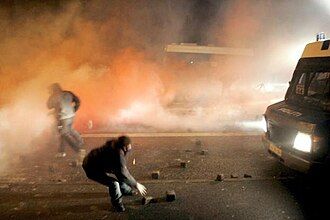 Protesters enshrouded in tear gas during a riot.