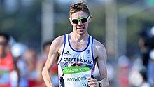 Man in sunglasses and a white top running.