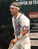 A brown-haired man in a white polo shirt