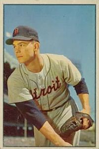 A man in a gray baseball uniform with blue under-sleeves and cap