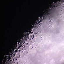 Lunar craters as captured through the backyard telescope of an amateur astronomer, partially illuminated by the sun on a waning crescent moon.