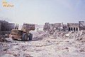 A crane pushes the wreckage of Qatif's castle houses after their removal.