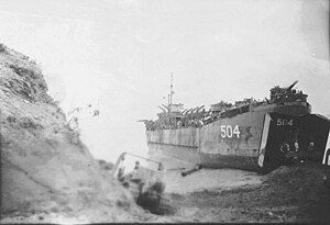 LST-504 beached at Chim Wan, Okinawa 8 June 1945 while being unloaded by Navy Seabees.