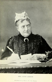 Stern-looking older woman with glasses seated at a desk, writing with a quill pen