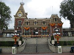 A flight of stairs lead to an old-fashioned railroad station building.