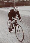 A male cyclist on a bicycle looking up at the camera