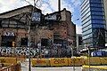 View of Carrer Pallars in Poblenou, showing renovation of underground infrastructure, as well as one of many former factories next to a modern building.