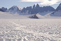 An Image of the Taku Towers, two stark peaks with a glacier below them.