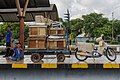 A number of transport workers waiting to load cargo and motorcycles with carts