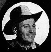 A smiling man wearing a cowboy hat