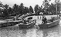 SBD Dauntless being moved small bulldozer and two plywood Landing Craft (LCVPs)