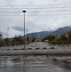 a road surrounded by trees with mountains in the background