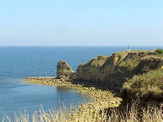 Present day view of the cliff of Pointe du Hoc with the monument on the top-right.