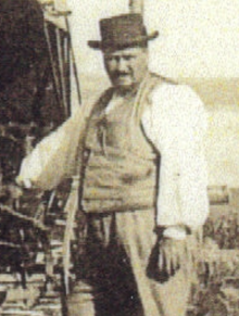 Black and white photo of a black man in white shirt and vest