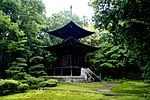 Two-storied wooden pagoda with a square lower and a round upper floor.