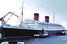 Ocean liner, with two tugboats next to it