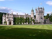 Balmoral Castle, with the Royal Standard of Scotland flying from a flagpole mounted on the roof of its cap-house