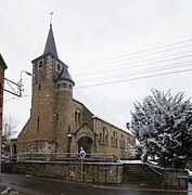 Religious building in stone in Neo-Romanesque style under snow.