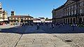 Plaza do Obradoiro as viewed from the Hostal dos Reis Catolicos. The Santiago de Compostela Cathedral is on the left. Large groups of pilgrims clap and celebrate their completion of the Camino de Santigo upon entering the Plaza and congregate in the square, as seen in this image