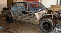 A race car stripped down to its roll cage and firewalls