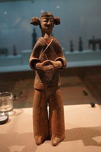 Colored standing female figurine with double hair buns, holding a hu (ritual baton)