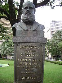 A bronze bust of a bearded man sits atop a plinth inscribed with a dedicatory inscription for the Centenario de D. Pedro the second