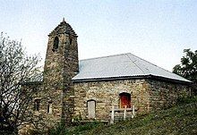 Photo of a small brick building on a hillside.