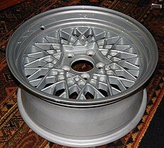 An aluminium alloy wheel designed to recall the crossed spokes of a wire wheel