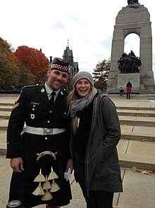 Photo of Corporal Nathan Cirillo being photographed in uniform next to a tourist days before his death at the tomb of the unknown soldier, seen in the background of the photo.