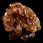 A cluster of orange to red almandine garnet crystals.