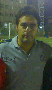 A close-cropped picture of a man standing on a football field.