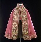 A cloak, 1580-1600 V&A Museum no. 793-1901 with techniques - Red satin, couched and embroidered with silver, silver-gilt and coloured silk threads, trimmed with silver-gilt and silk thread fringe and tassel, and lined with pink linen