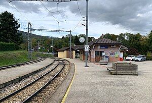 Station platform with a station shelter next to a railway line