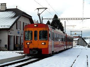 Red and orange train next to station platform