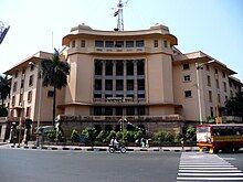 A five-storied building in cream colour with multiple columns in front