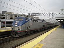 A train with a diesel locomotive at a large train station