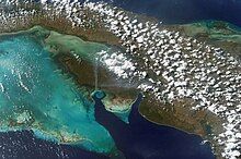 View from the air of coastline, sea and vegetation-covered land