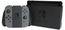 A Nintendo Switch console in docked mode and Joy-Con controllers in grip configuration.