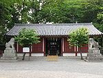 A building with red and white walls and a tile roof.