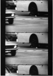 Black and white image of Rattay's body lying in the front wheel arch of a bus