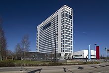 A tall white office building with a blue sky in the background