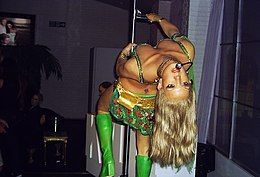 Spears Leaning backward from a revolving pole with her "I'm a Slave 4 U" outfit