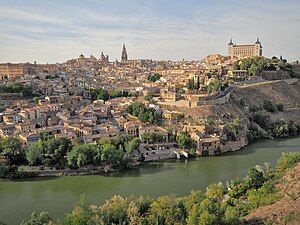 View of the city of Toledo situated on a hill with a river in the foreground