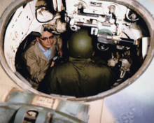 A HEL researcher and an Army soldier conduct tests inside a M113 Armored Personnel Carrier.