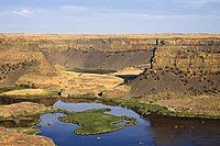 Plateau with steep walls of a former waterfall above a river