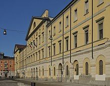 Photograph of the façade of an ochre-coloured building.